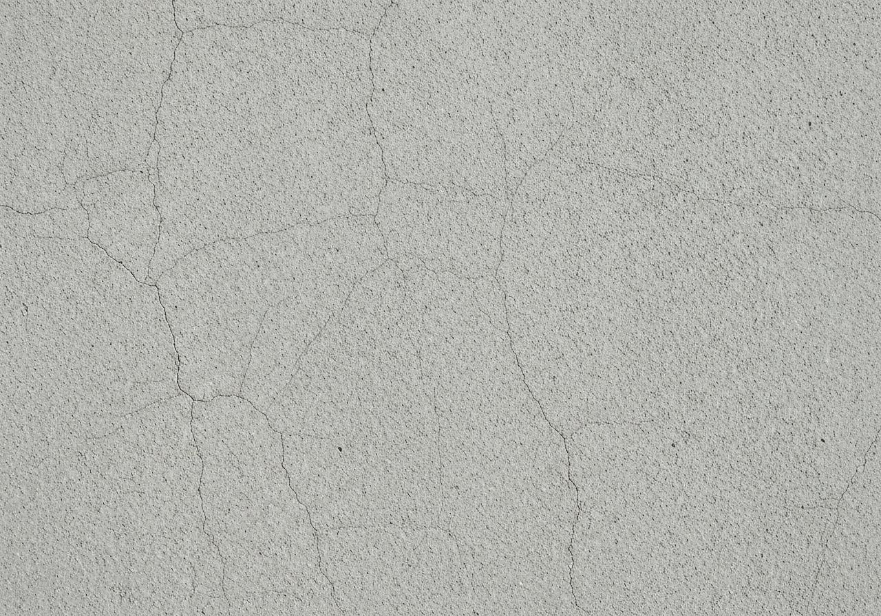 Gros plan fissure béton avec réseau microfissures surface